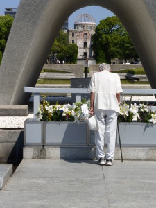 And old man in prayer for peace.  Note the Pond of Peace, the Flame of Peace and the Atomic Bomb dome all seen through this cenotaph.